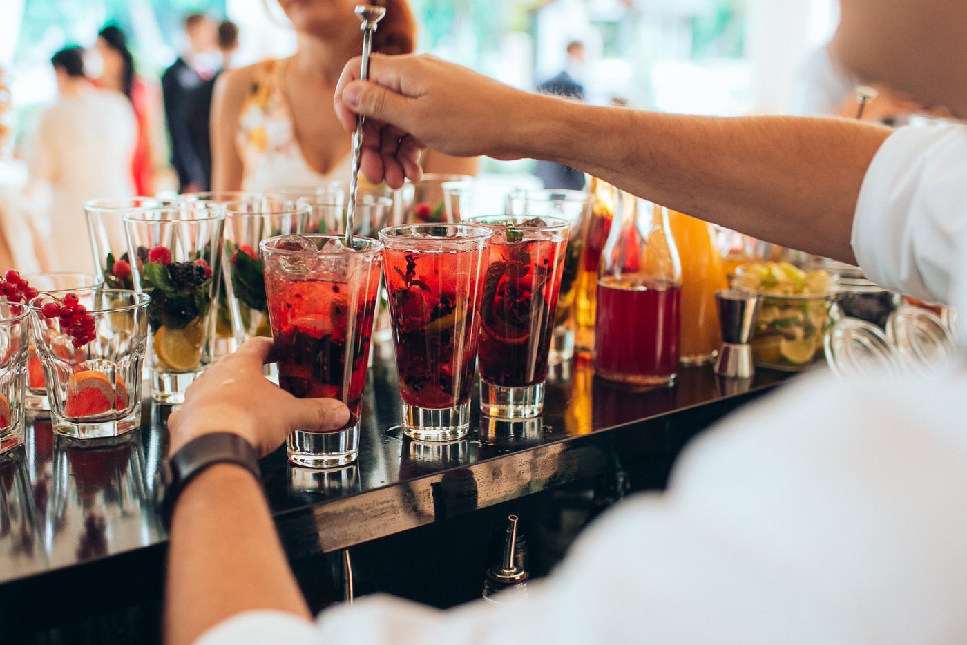 Barkeeper rührt Beeren-Drinks an der Bar einer Hochzeitsfeier