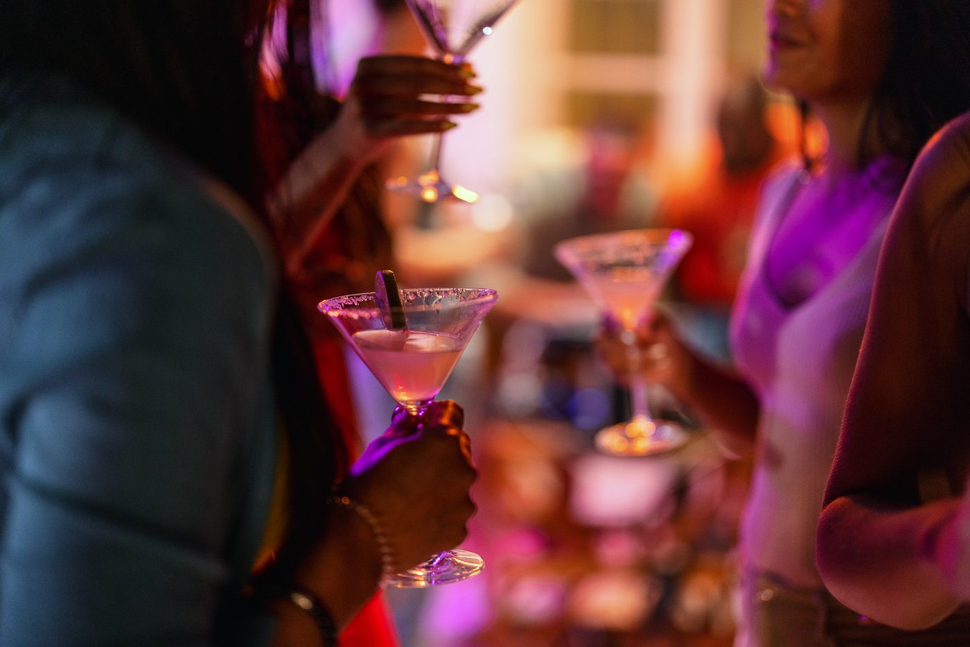 Gäste mit Martini-Cocktails auf einer Abendparty